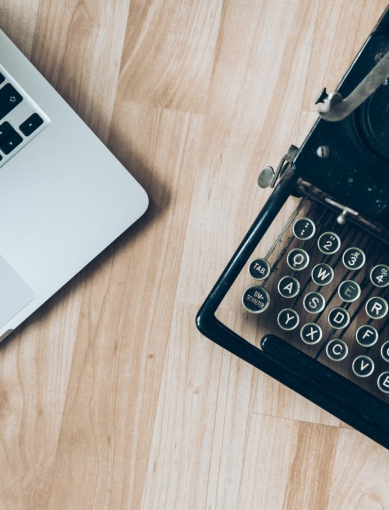 MacBook beside typewriter machine